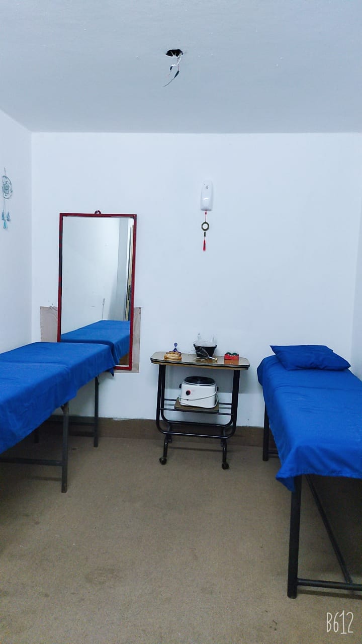 Cabina de masaje en Relax Masajes Paraná con camilla vestida en sábanas blancas puras, iluminación cálida de velas y difusor de aromaterapia